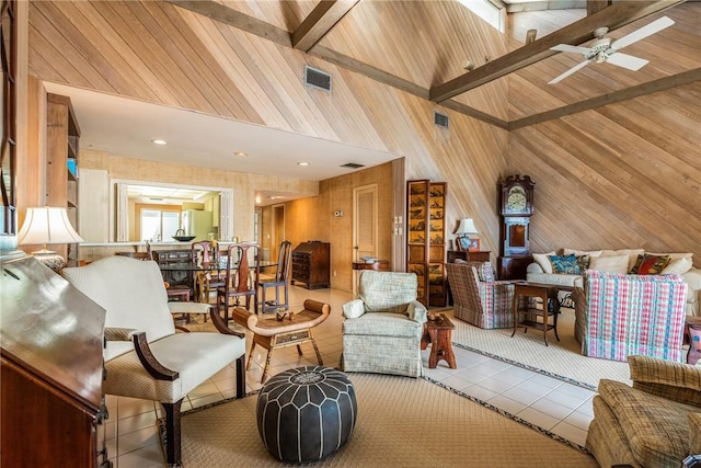 living room featuring ceiling fan, beamed ceiling, wooden walls, high vaulted ceiling, and light tile patterned floors