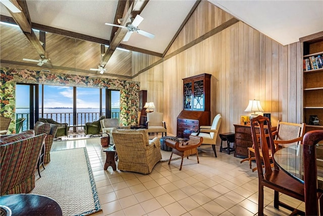 living room with light tile patterned flooring, a water view, lofted ceiling with beams, and built in shelves