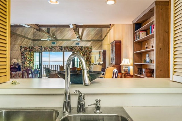 kitchen with ceiling fan, sink, built in features, and beam ceiling