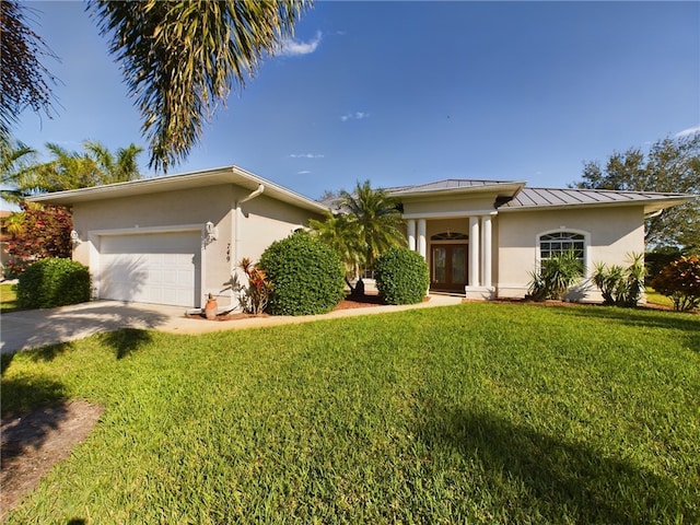 view of front of property with french doors, a garage, and a front lawn