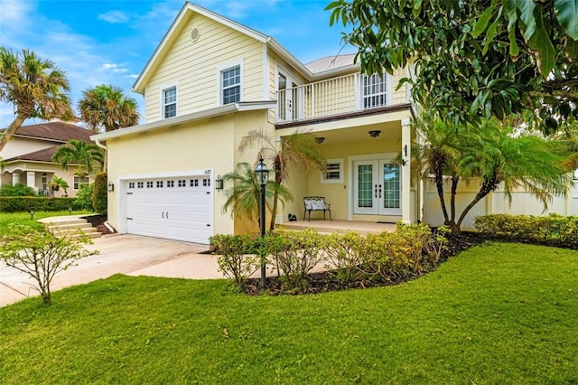 view of front of house with a front yard, french doors, a balcony, and a garage