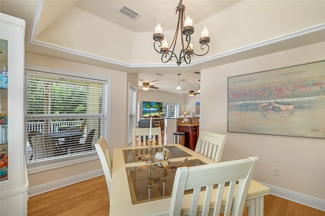 dining room with a raised ceiling, sink, ceiling fan with notable chandelier, and hardwood / wood-style floors