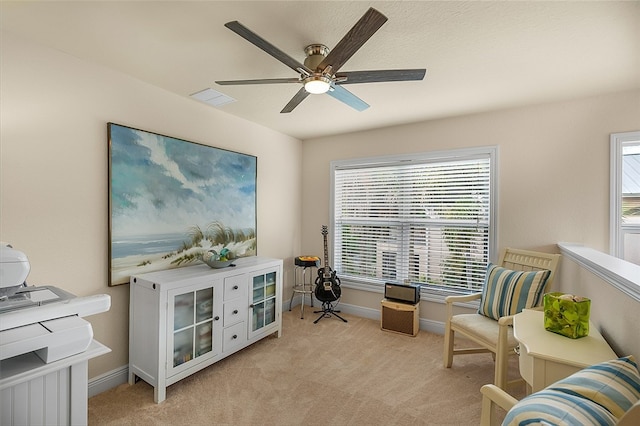 living area featuring ceiling fan and light colored carpet