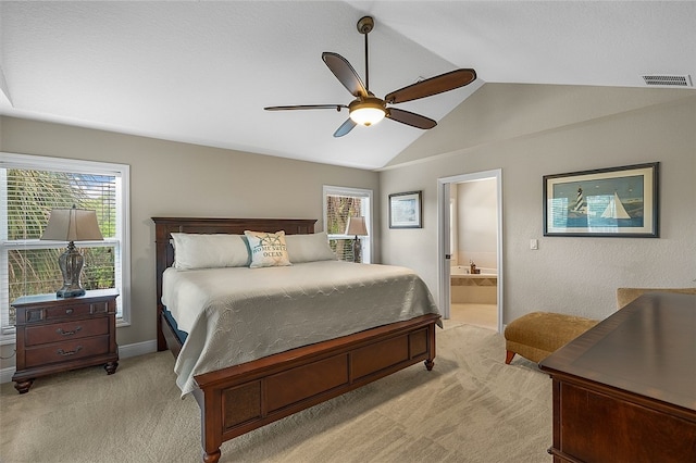 carpeted bedroom with ensuite bath, ceiling fan, and vaulted ceiling