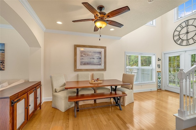 dining space with ceiling fan, crown molding, and light wood-type flooring