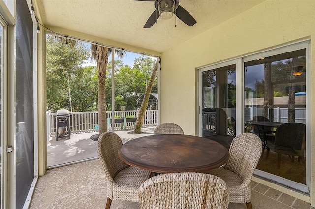 sunroom with ceiling fan and vaulted ceiling