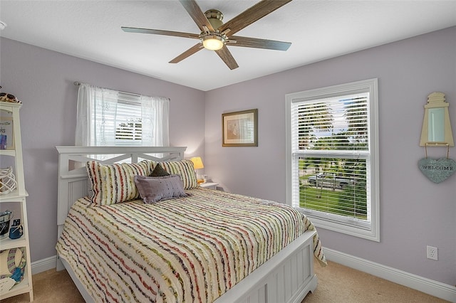 carpeted bedroom with ceiling fan and multiple windows