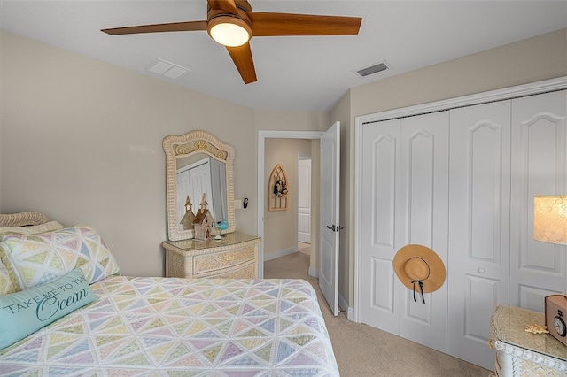 bedroom with ceiling fan, light colored carpet, and a closet