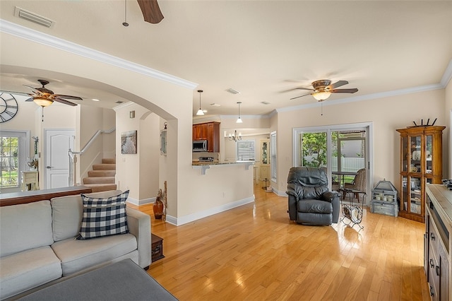 living room featuring ceiling fan, light wood-type flooring, and crown molding