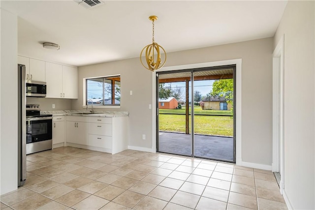 kitchen with stainless steel appliances, hanging light fixtures, sink, and white cabinets