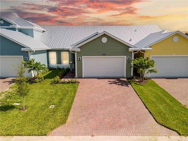 ranch-style home featuring a garage and a yard