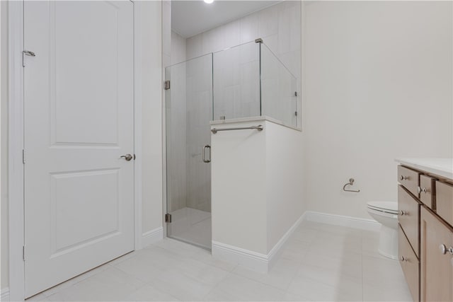 bathroom featuring toilet, vanity, tile patterned flooring, and a shower with shower door