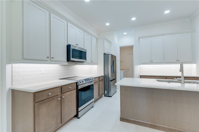 kitchen featuring stainless steel appliances, sink, ornamental molding, backsplash, and white cabinets