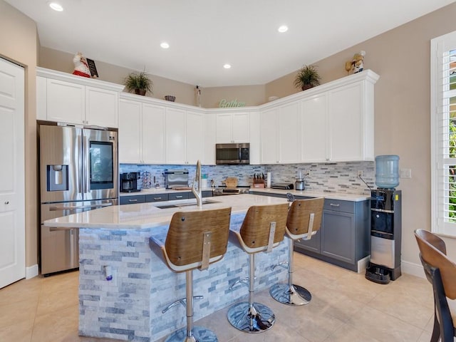 2785 Grand Isle Way SW, Vero Beach, FL 32968 - kitchen featuring stainless steel appliances, decorative backsplash, light tile patterned floors, an island with sink, and recessed lighting