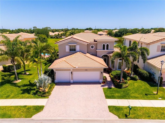 2785 Grand Isle Way SW, Vero Beach, FL 32968 - mediterranean / spanish house with a tiled roof, stucco siding, decorative driveway, a garage, and a front yard