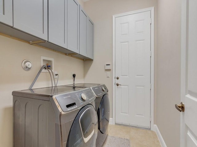 2785 Grand Isle Way SW, Vero Beach, FL 32968 - laundry room with washing machine and clothes dryer, cabinet space, light tile patterned floors, and baseboards