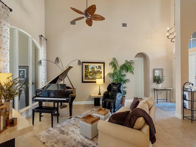 2785 Grand Isle Way SW, Vero Beach, FL 32968 - tiled living area with a high ceiling, arched walkways, ceiling fan, and baseboards