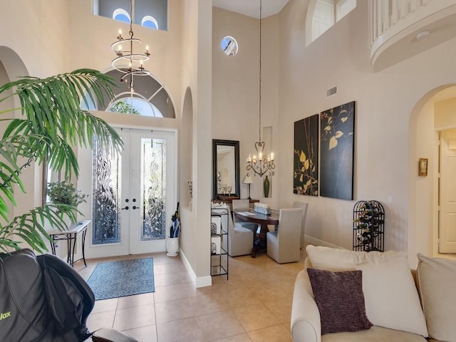 2785 Grand Isle Way SW, Vero Beach, FL 32968 - tiled entrance foyer with a chandelier, arched walkways, a towering ceiling, french doors, and baseboards