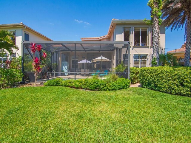 2785 Grand Isle Way SW, Vero Beach, FL 32968 - back of property with stucco siding, a lawn, and a lanai