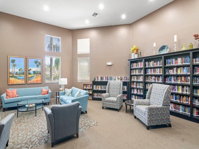 2785 Grand Isle Way SW, Vero Beach, FL 32968 - living area featuring carpet floors, wall of books, recessed lighting, and a towering ceiling