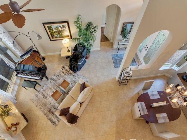 2785 Grand Isle Way SW, Vero Beach, FL 32968 - living area with arched walkways, tile patterned floors, a ceiling fan, and baseboards