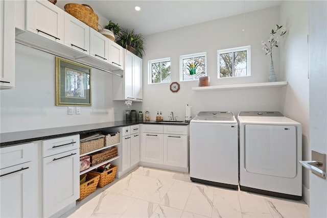 laundry area with washing machine and dryer, sink, and cabinets