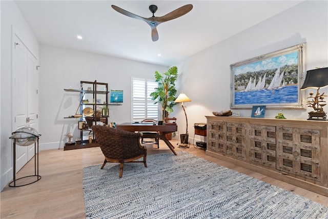 home office with ceiling fan and light hardwood / wood-style flooring