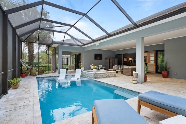 view of pool featuring outdoor lounge area, a patio, glass enclosure, and an in ground hot tub