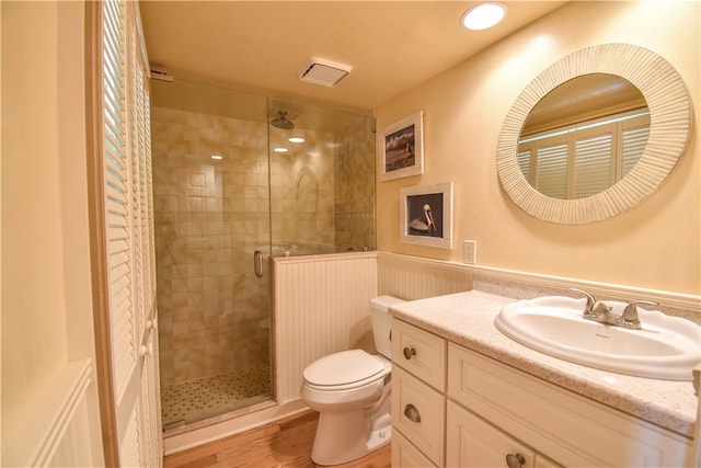 bathroom featuring an enclosed shower, vanity, hardwood / wood-style flooring, and toilet