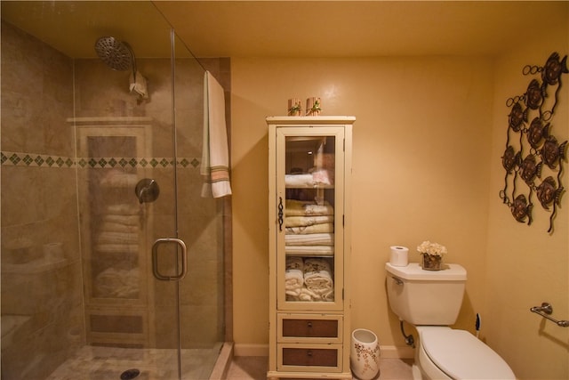 bathroom featuring toilet and a shower with door