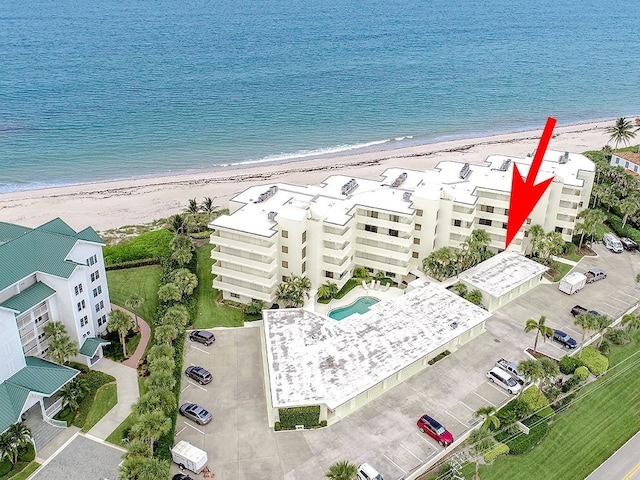 birds eye view of property with a water view and a beach view