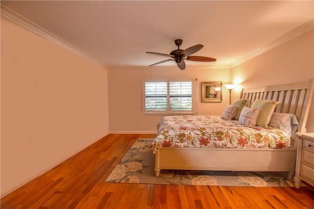 unfurnished bedroom with ceiling fan, wood-type flooring, and ornamental molding