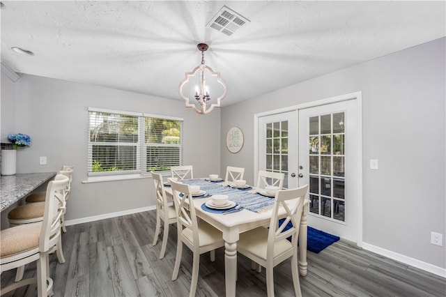 dining room featuring baseboards, visible vents, wood finished floors, and french doors