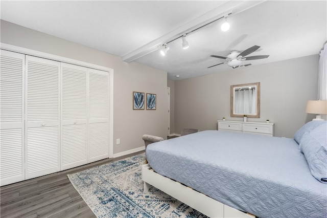 bedroom featuring a closet, ceiling fan, track lighting, wood finished floors, and baseboards