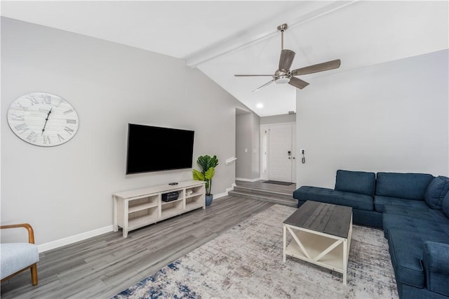 living area with lofted ceiling with beams, ceiling fan, wood finished floors, and baseboards