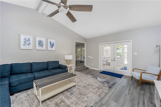 living area featuring french doors, vaulted ceiling with beams, a ceiling fan, wood finished floors, and baseboards