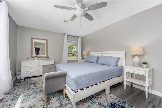 bedroom featuring a ceiling fan, visible vents, baseboards, and wood finished floors