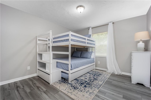 bedroom featuring baseboards and wood finished floors
