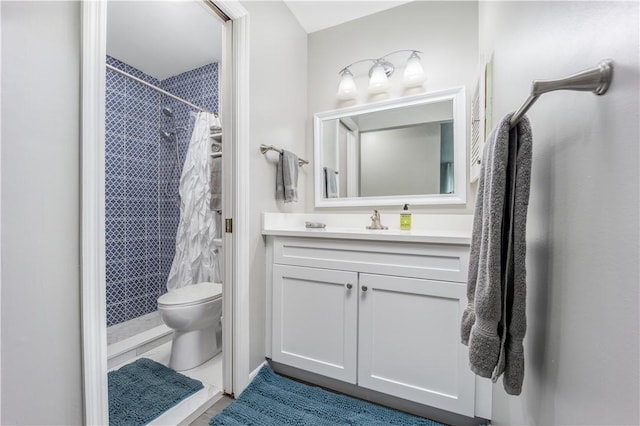 bathroom with tiled shower, vanity, toilet, and tile patterned floors