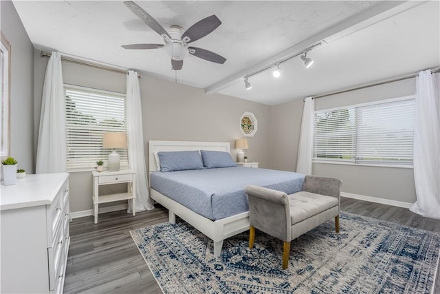 bedroom with rail lighting, ceiling fan, baseboards, and wood finished floors