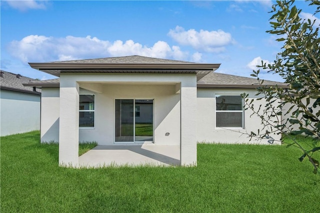 back of house with a lawn and a patio