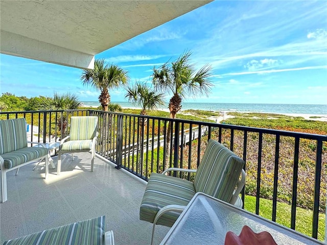 balcony featuring a water view and a view of the beach