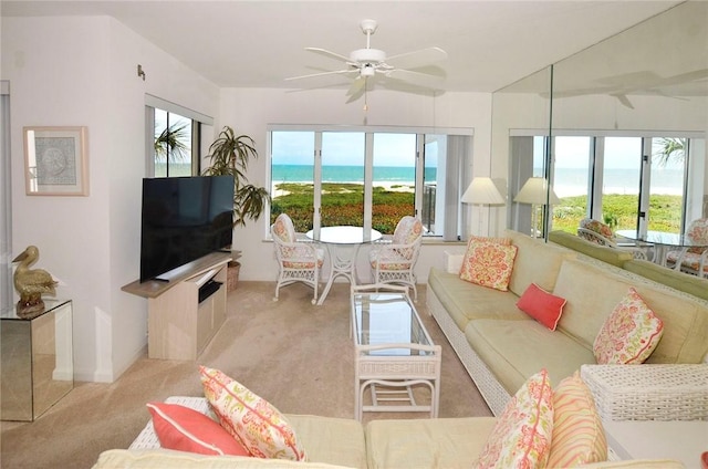 living area featuring light carpet and ceiling fan