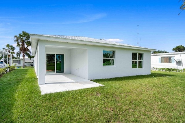 back of house with a patio and a lawn