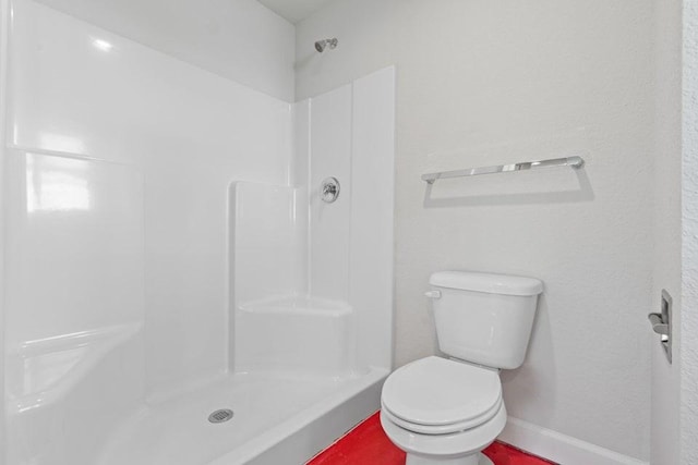 bathroom featuring toilet and walk in shower