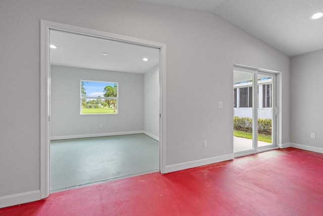 unfurnished room featuring concrete flooring and lofted ceiling