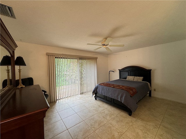 tiled bedroom with ceiling fan, access to exterior, and a textured ceiling