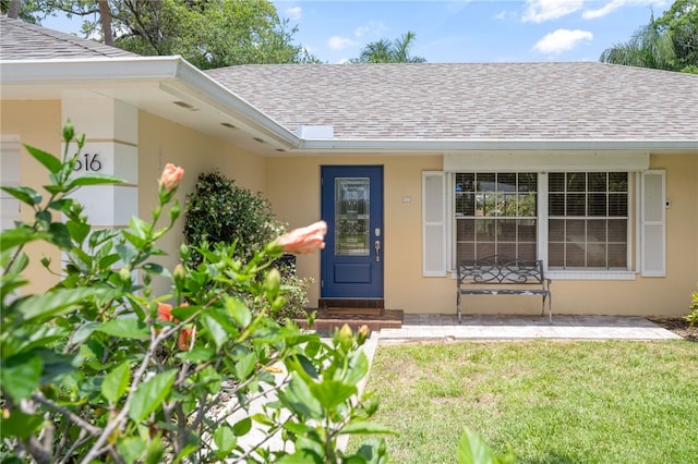616 Broadway St, Vero Beach, FL 32960 - doorway to property with roof with shingles, a yard, and stucco siding