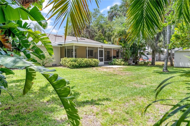 616 Broadway St, Vero Beach, FL 32960 - rear view of property with a sunroom, stucco siding, a lawn, and a shingled roof
