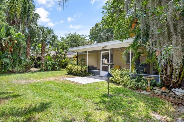 616 Broadway St, Vero Beach, FL 32960 - rear view of property with ceiling fan, a lawn, a sunroom, and a patio area